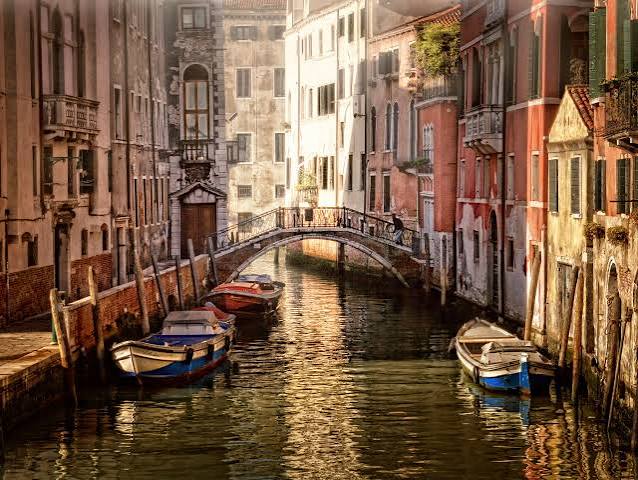 Venice gondola through back canals at sunset